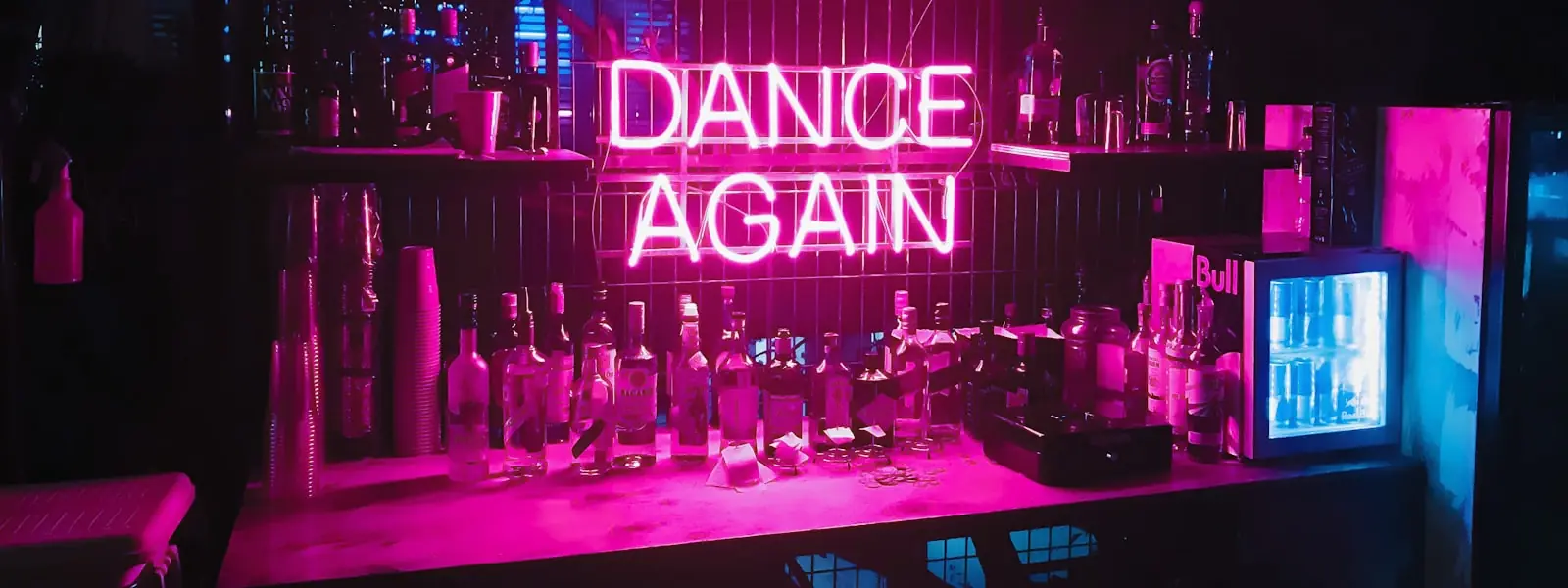 A neon "Dance Again" sign