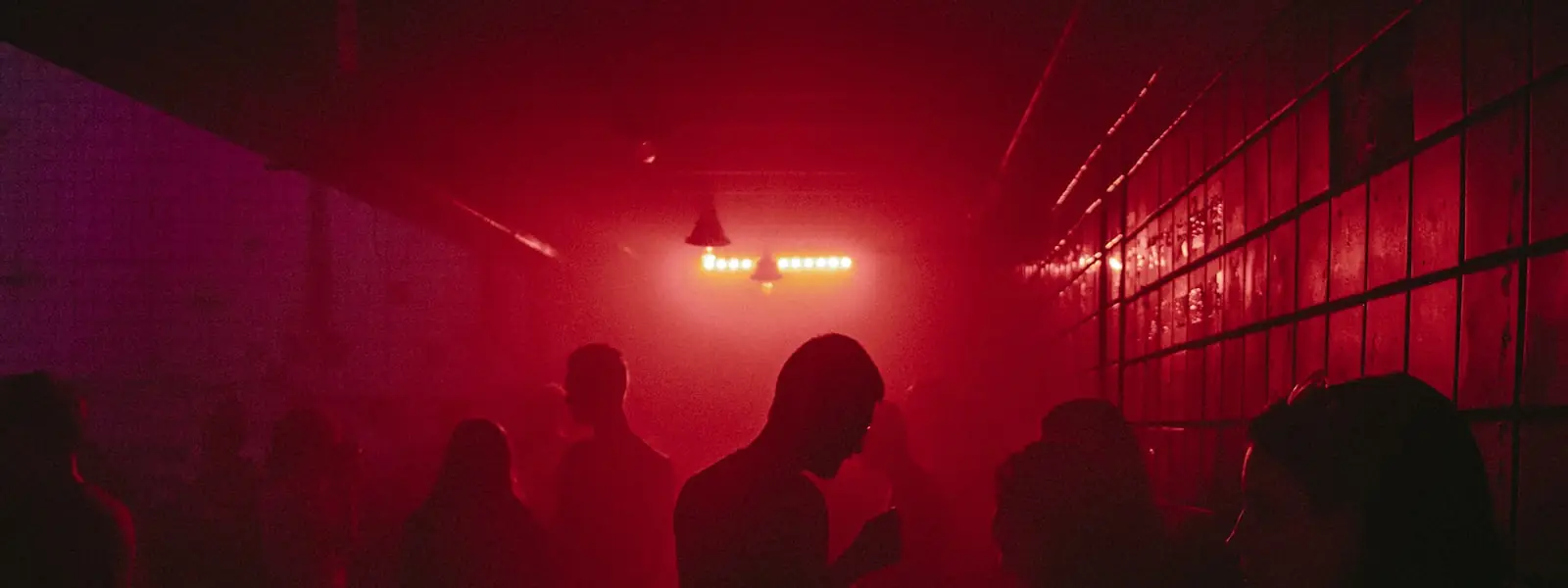 Silhouettes of a crowd in red light